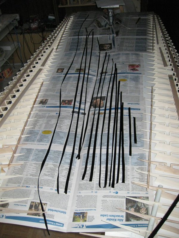 Rovings auf Zeitungspapier tränken um überflüssiges Harz aufzusaugen. Für schnellere und gründlichere Benetzung versetze ich das Harz mit 20-30 % Spiritus der beim laminieren und in der Anfangshärtung verdunstet