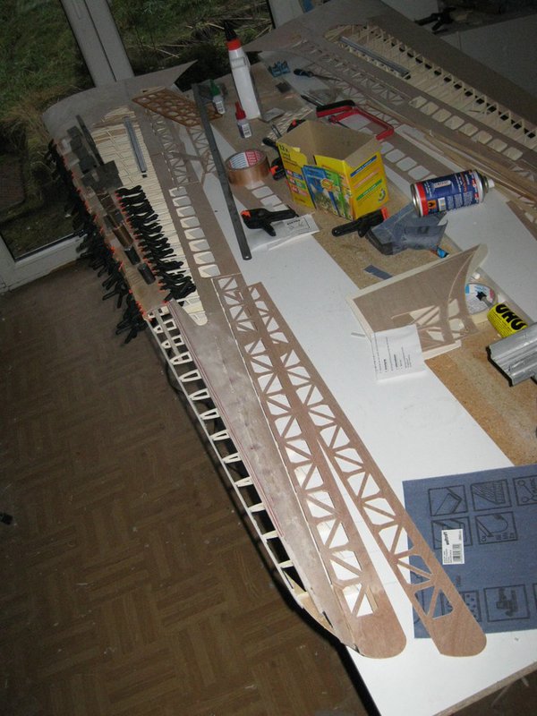 Die Beplankung wird mit Klammern, Beiklemmleisten, Gewichten und Parkettklebeband um die Nase aufgepreßt