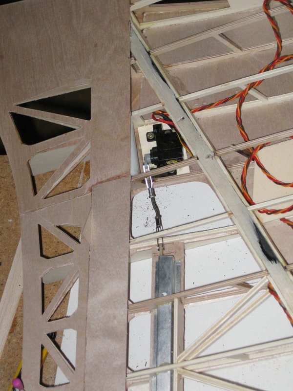 Jetzt werden auch schon die Störklappenanlenkungen unter Putz eingebaut. Es genügt wenn ich die Beplankung im Schadensfall aufschneiden muß, bis da hin bleibt das Servo ohne Schachtdeckel unsichtbar