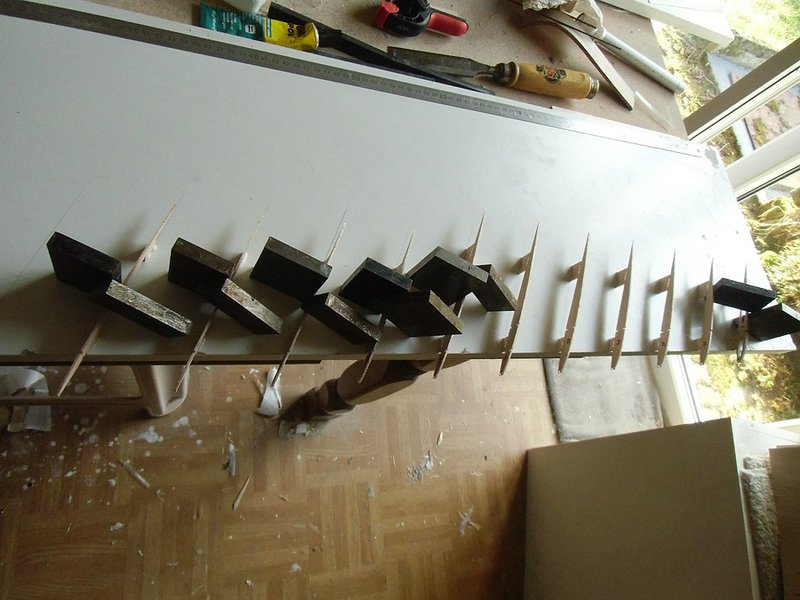 Klein0511CIMG0320.jpg (186.98 KiB) 18318 mal betrachtet Aufstellen der Rippen. Geklebt wird mit Holzleim, das hält auf der Beschichtung des Baubretts gerade so gut dass es beim einziehen der Holme, Verkastungen und Beplankung nicht abgeht, aber beim umdrehen der Bauteile bei sanfter Gewalt trennt.