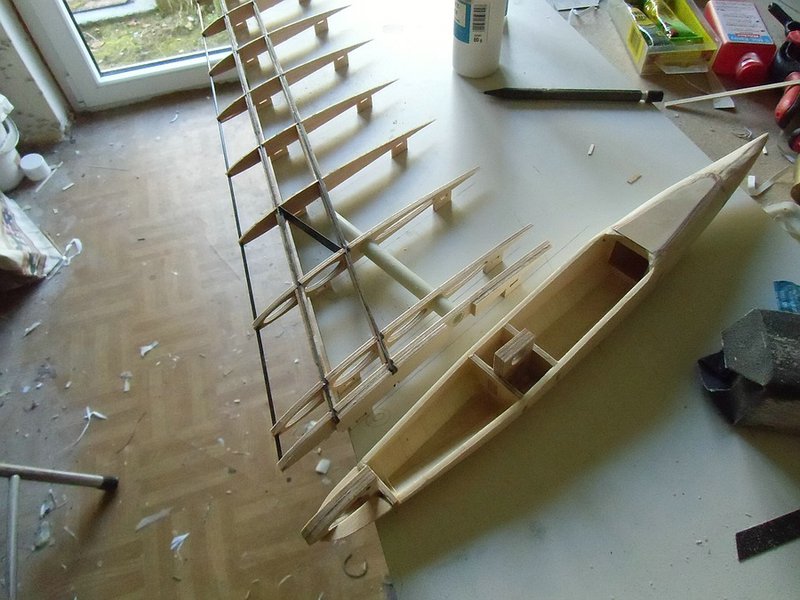 Klein0611CIMG0344.jpg (198.94 KiB) 11823 mal betrachtet ....und so rum kommt der Rumpf nachher an den Flügel. Man sieht wie die Pylone nachher in Aussparungen der Wurzelrippen eingtreifen. Hinten kommt der Steckungsstab durch, vorne die Torsionsstifte. Zum montieren des Flügels werden nur die Flächen aufgeschoben und mit einem Tesastreifen oder Multilock gesichert. Bei seitlicher Belastung stützt sich die zweite Flügelrippe auf der Rumpfseitenwand ab.